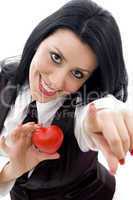 female holding a red heart pointing at camera