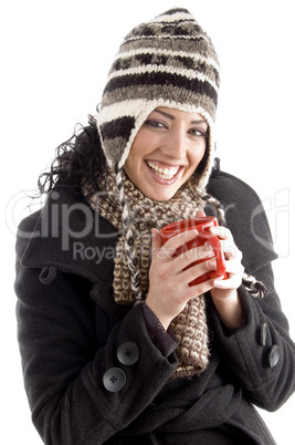 smiling woman with winter cap holding coffee mug