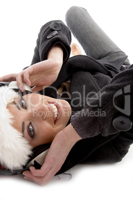 smiling woman listening music and wearing christmas hat