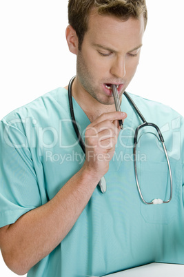 doctor putting pen in his mouth and looking in writing pad