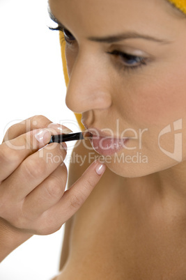 beautician putting lipstick on female's lips