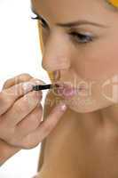 beautician putting lipstick on female's lips