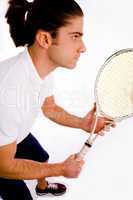 side pose of player carrying racket