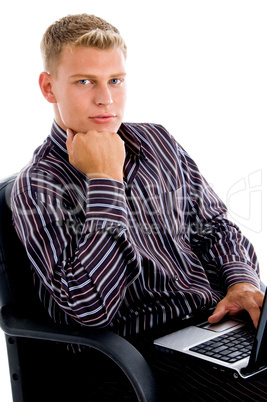businessman sitting with laptop and chin resting on his fists
