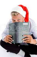 sitting man with book and christmas hat