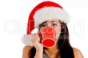 girl drinking coffee wearing christmas hat