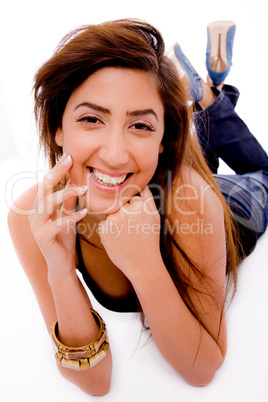 front view of smiling young woman holding her face