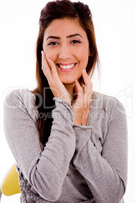 portrait of smiling young woman holding her face