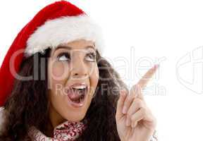 young woman with christmas hat indicating upward