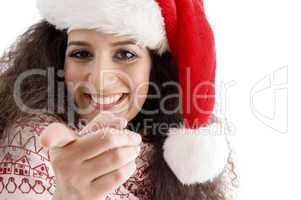 young female with christmas hat pointing at camera
