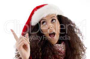 young woman with christmas hat pointing aside