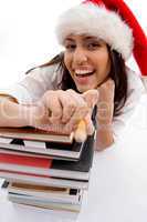 cheerful student wearing christmas hat with stack of books
