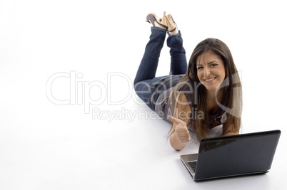 young female lying down and working on laptop