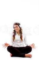 young woman doing meditation with music
