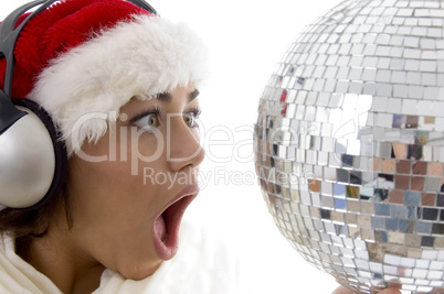 surprised woman looking to disco ball and wearing christmas hat