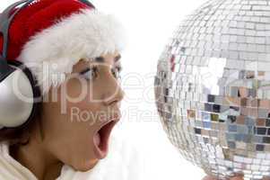 surprised woman looking to disco ball and wearing christmas hat