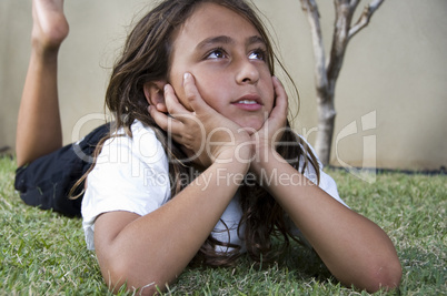 little girl lying on grass and looking side