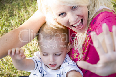 young woman and little baby sitting on green grass