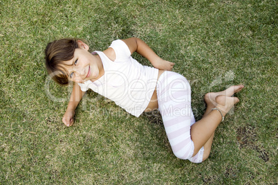 young cute girl lying on the grass