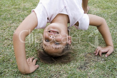 girl doing cartwheel in the grass