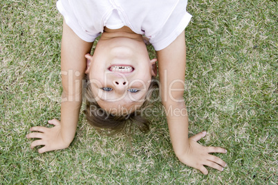 girl doing cartwheel in the grass