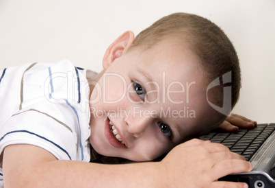 little boy lying on laptop