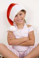 smiling girl with crossed arms wearing christmas hat