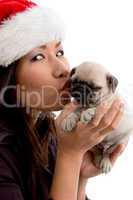 female wearing christmas hat and kissing puppy