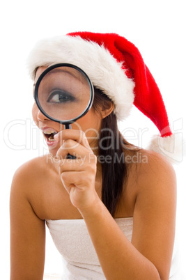 woman posing in towel and wearing christmas hat with magnifier