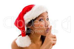 woman with christmas hat and gesturing to keep silent