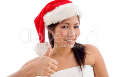 young woman with christmas hat showing thumb up