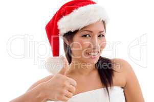 young woman with christmas hat showing thumb up