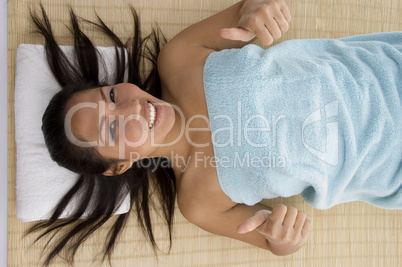 laying young woman showing thumb up