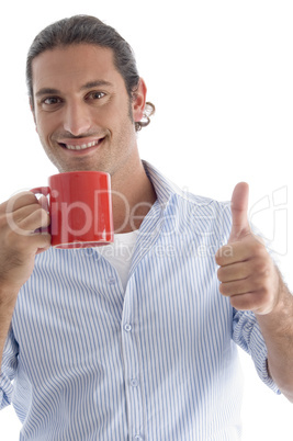 young american male holding coffee mug with thumbs up