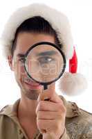 male holding magnifier and wearing christmas hat