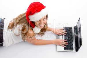 laying young female with christmas hat and laptop
