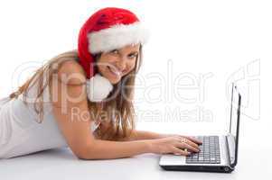 laying female with christmas hat and laptop