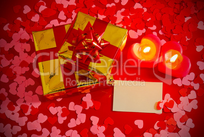 Presents and two heart shaped candles with blank card