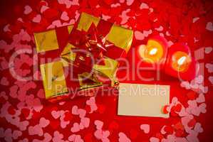 Presents and two heart shaped candles with blank card