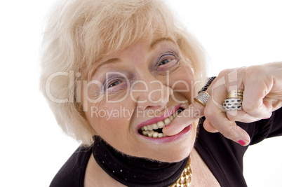 close up of old woman keeping finger in her mouth