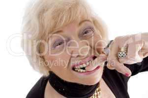 close up of old woman keeping finger in her mouth