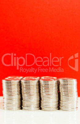 Coins stacked in bars against red background