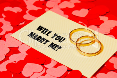 Two rings and a card with marriage proposal