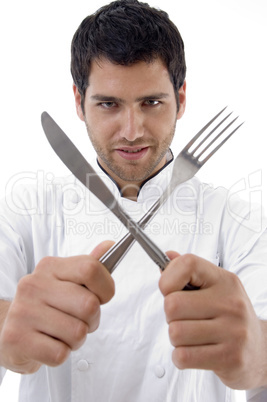 chef holding crossed fork and knife