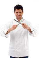 portrait of young male chef holding fork and knife
