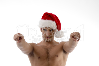 cool muscular man wearing christmas hat and pointing towards
