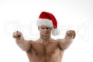 cool muscular man wearing christmas hat and pointing towards