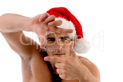 muscular male with christmas hat showing framing gesture