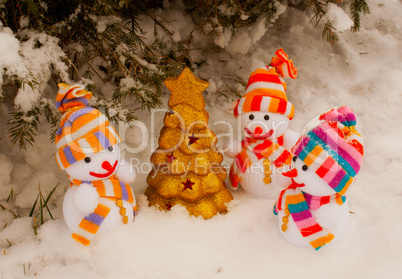 Three snowmen with golden evergreen tree