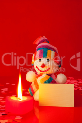 Snowman with burning heart shaped candle